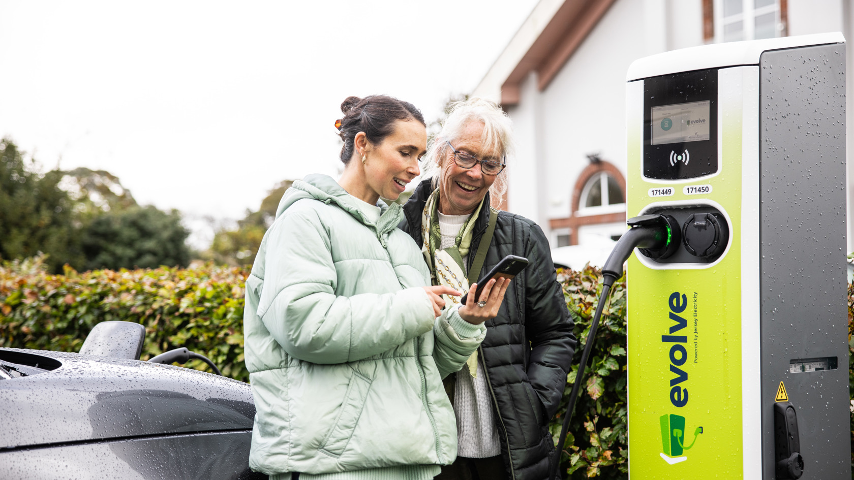Evolve charge point with two ladies standing by to start their charge